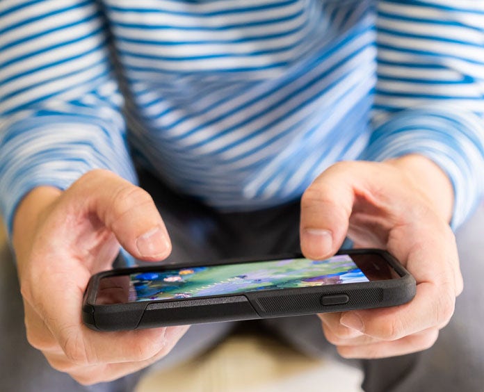 A close up of a person holding a phone playing a game on the phone
